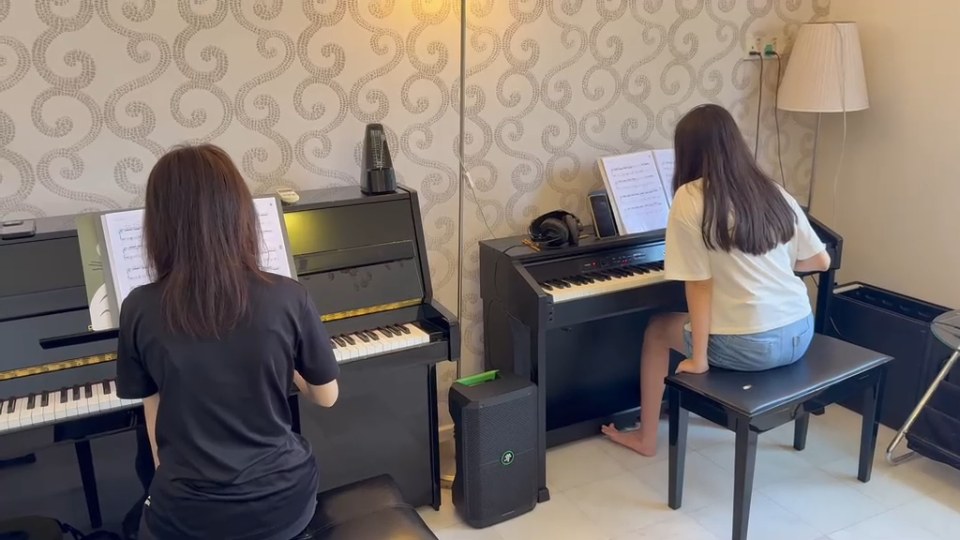 A short glimpse of two learners at the keys.